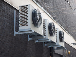 Three commercial mini-split ac outdoor units hanged on a wall.